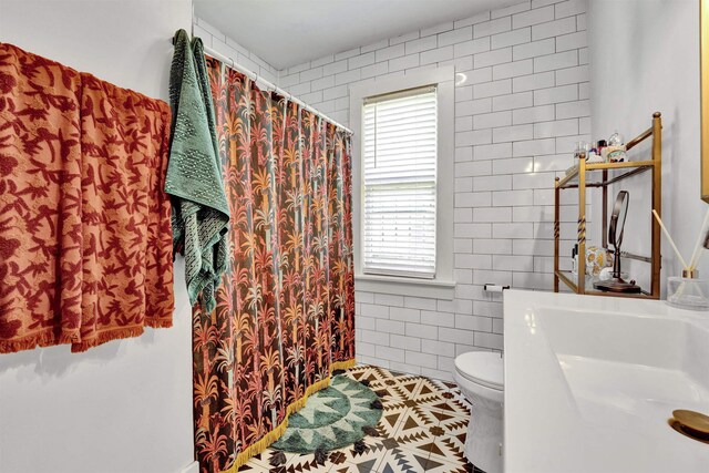 1150 Tanglewood St, Memphis, TN 38114 - bathroom with toilet, healthy amount of natural light, a sink, tile walls, and tile patterned floors
