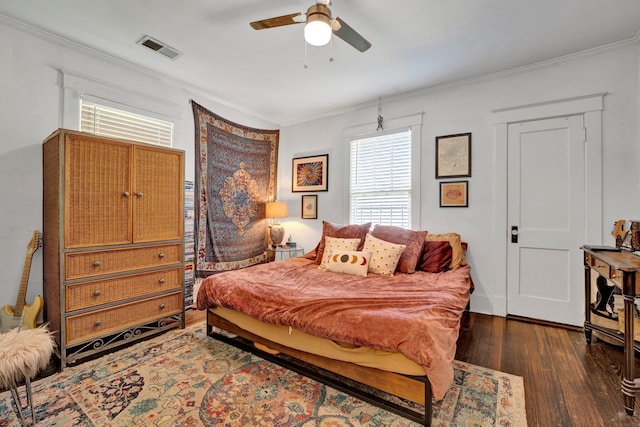 bedroom featuring ornamental molding, ceiling fan, and dark wood-type flooring