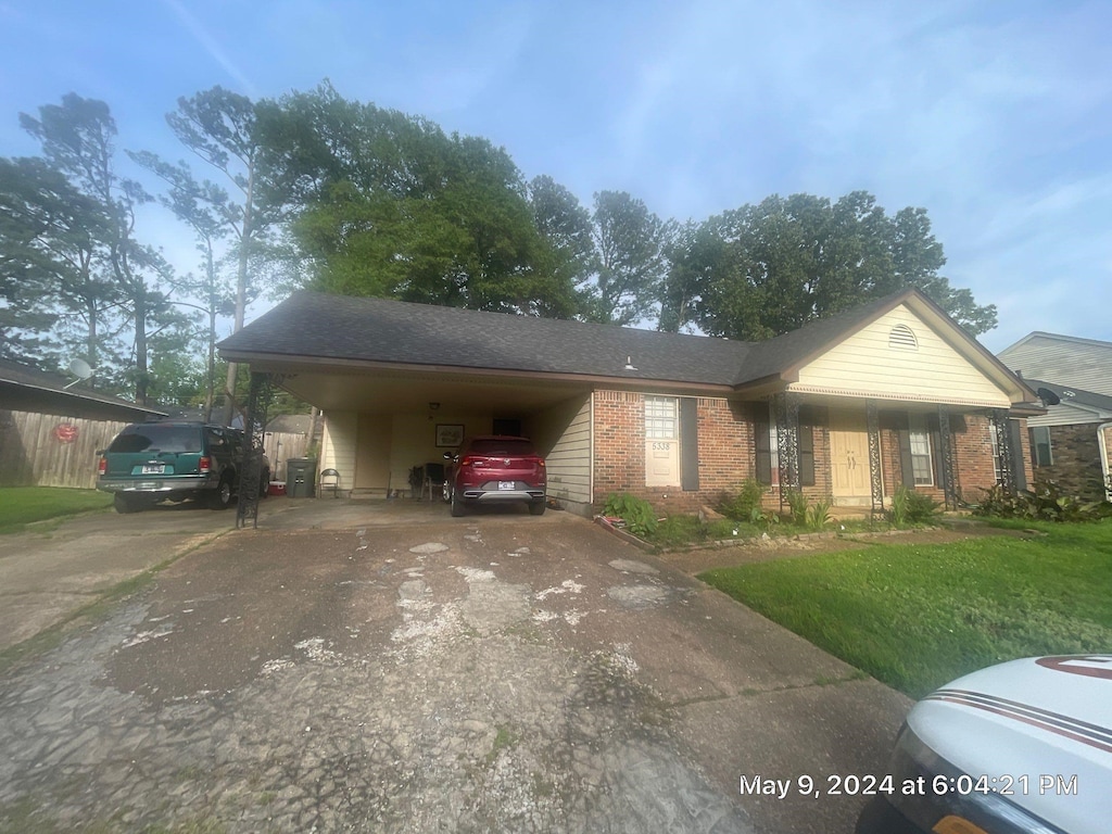 view of front of house with a carport and a front lawn