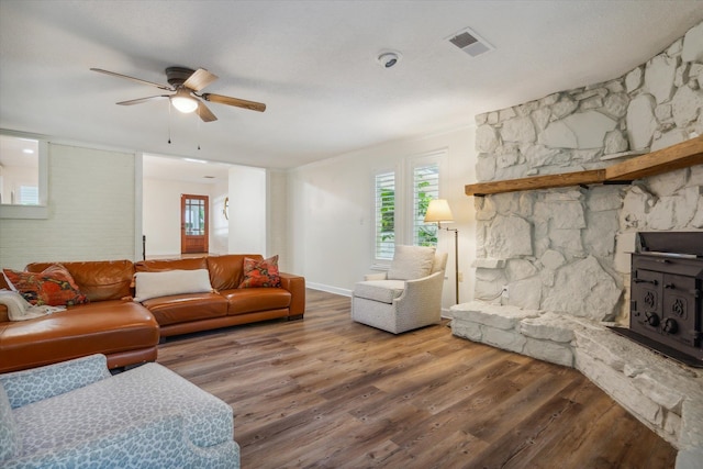 living room featuring hardwood / wood-style flooring, a fireplace, ceiling fan, and a textured ceiling