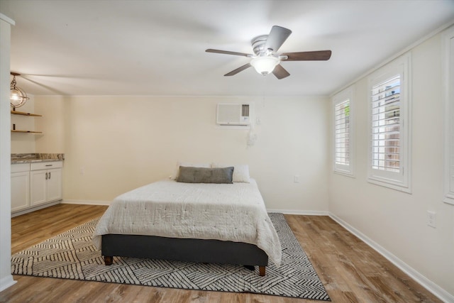 bedroom featuring ceiling fan, hardwood / wood-style floors, and a wall mounted air conditioner