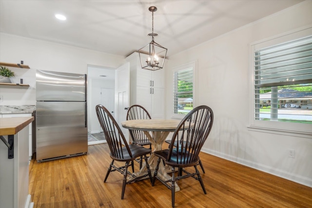 dining space with a notable chandelier and light hardwood / wood-style floors