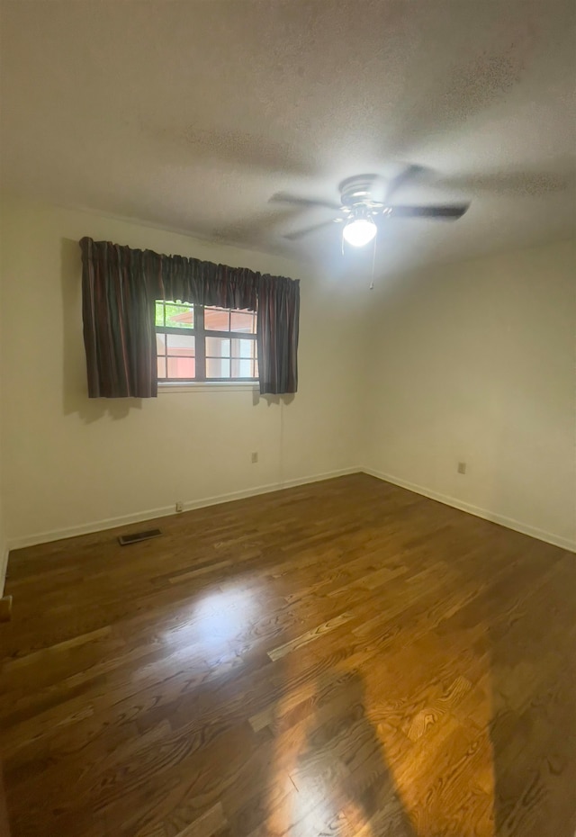 empty room featuring hardwood / wood-style floors, ceiling fan, and a textured ceiling