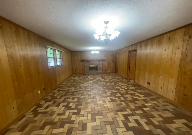 basement featuring a notable chandelier, parquet floors, a brick fireplace, and wood walls