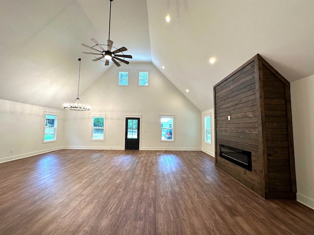 unfurnished living room featuring high vaulted ceiling, a large fireplace, ceiling fan with notable chandelier, and dark hardwood / wood-style flooring