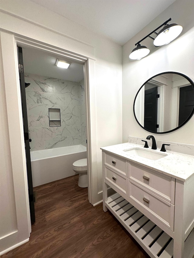 full bathroom with hardwood / wood-style floors, vanity, toilet, and tiled shower / bath combo