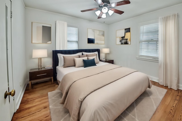 bedroom with ceiling fan, multiple windows, and light hardwood / wood-style flooring