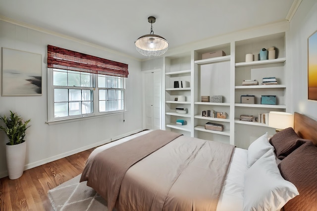 bedroom featuring crown molding and wood-type flooring