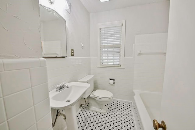 bathroom with tile floors, shower / bath combination, toilet, and tile walls