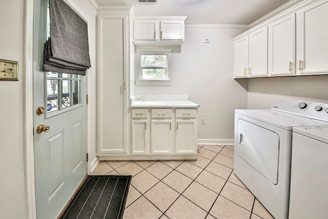 washroom featuring cabinets, washing machine and dryer, light tile floors, and crown molding