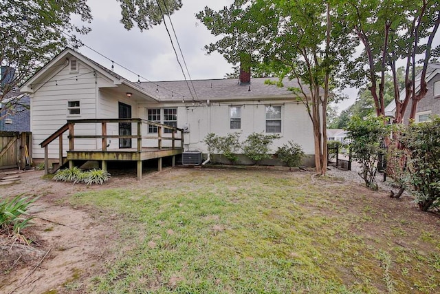 back of property with a deck, central air condition unit, and a lawn