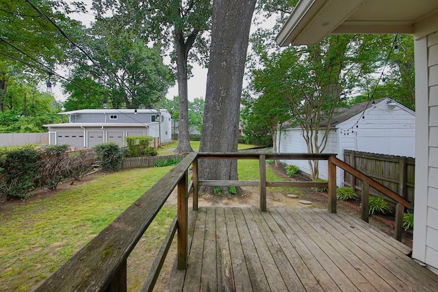 wooden deck with a garage and a lawn