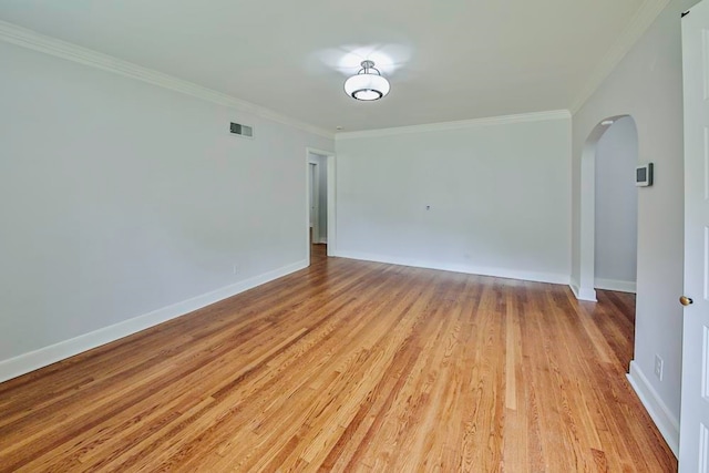 empty room with ornamental molding and light hardwood / wood-style floors