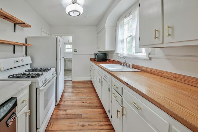 kitchen with light hardwood / wood-style floors, white range with gas stovetop, dishwasher, sink, and white cabinetry