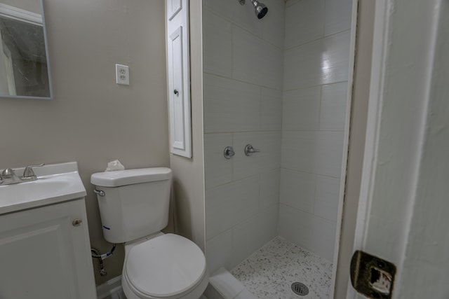 bathroom featuring tiled shower, vanity, and toilet