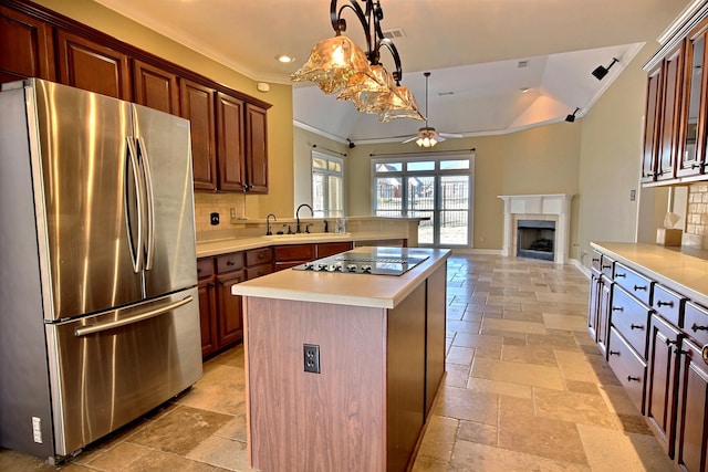 kitchen with black electric cooktop, stainless steel refrigerator, backsplash, and a center island