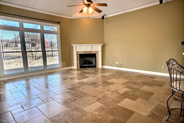 unfurnished living room featuring ceiling fan, a tiled fireplace, and ornamental molding