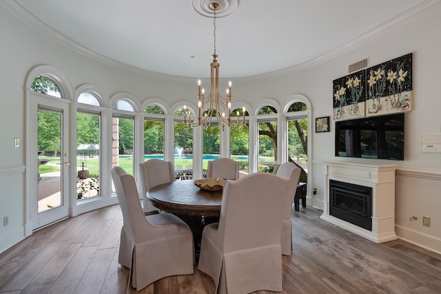 dining area featuring hardwood / wood-style floors, a chandelier, and ornamental molding