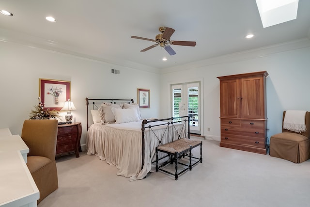 carpeted bedroom with access to outside, a skylight, ceiling fan, ornamental molding, and french doors