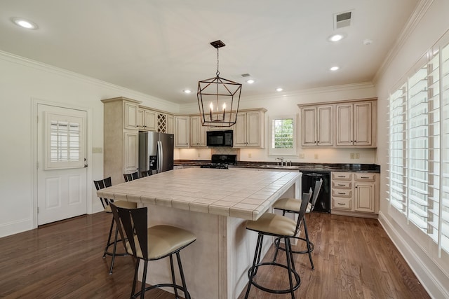 kitchen with a center island, black appliances, sink, and dark hardwood / wood-style flooring