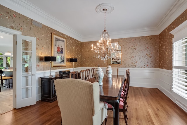 dining space featuring a chandelier, crown molding, and hardwood / wood-style floors