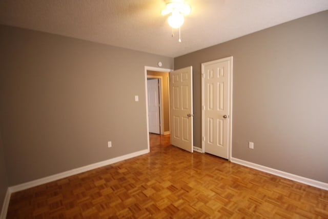 unfurnished bedroom with a textured ceiling and parquet floors