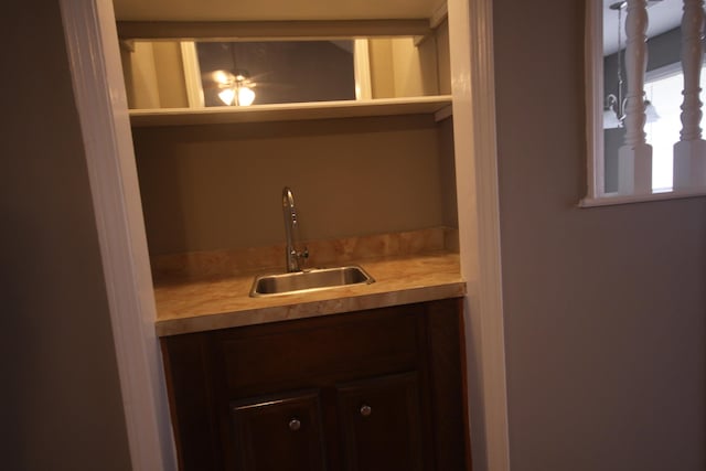 bar with sink and dark brown cabinetry