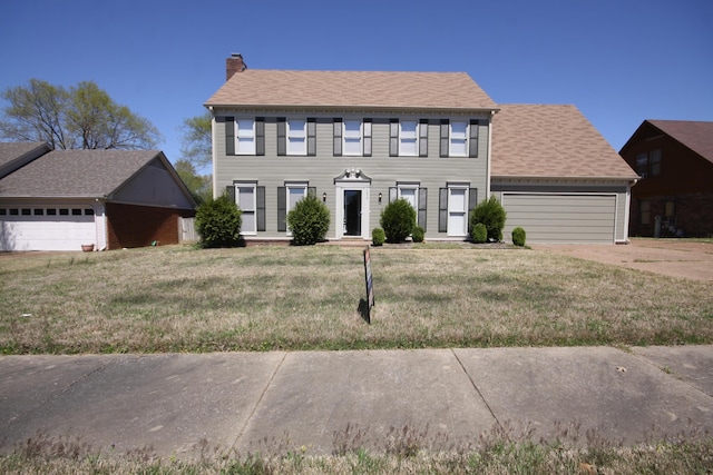 colonial inspired home with a garage and a front yard