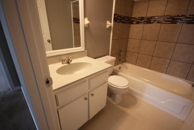 full bathroom with tile floors, tiled shower / bath, vanity with extensive cabinet space, and toilet