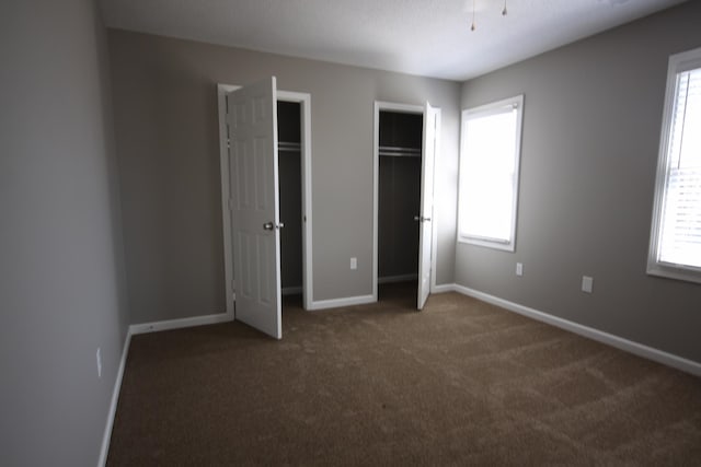 unfurnished bedroom with dark carpet