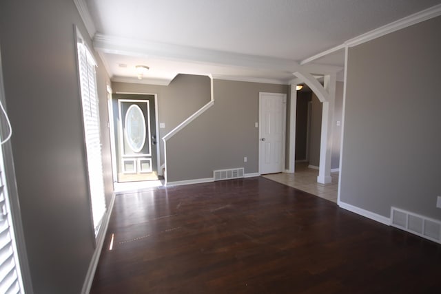 unfurnished living room with hardwood / wood-style flooring and crown molding