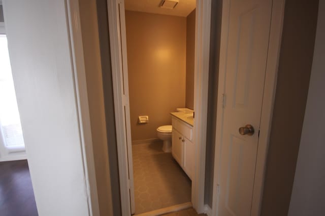 bathroom featuring tile floors, vanity, and toilet