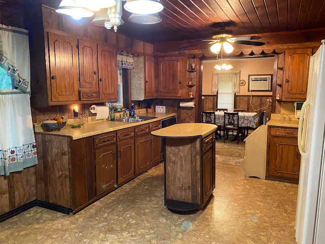 kitchen with a kitchen island, ceiling fan with notable chandelier, a wall mounted air conditioner, sink, and white fridge