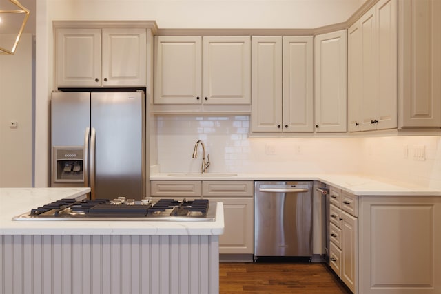 kitchen featuring tasteful backsplash, cream cabinets, dark hardwood / wood-style flooring, sink, and appliances with stainless steel finishes