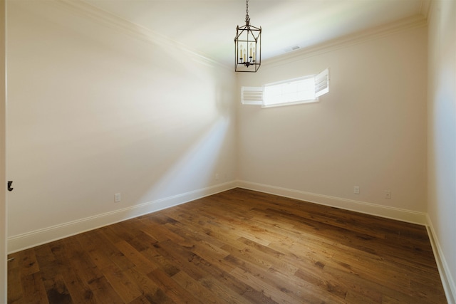 unfurnished room featuring a chandelier, hardwood / wood-style flooring, and ornamental molding