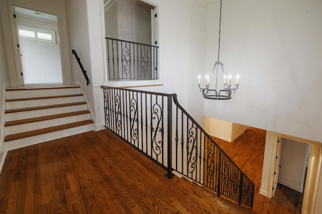 staircase featuring dark hardwood / wood-style floors and an inviting chandelier