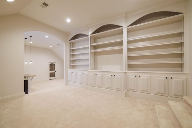 unfurnished living room with light carpet, lofted ceiling, and built in features