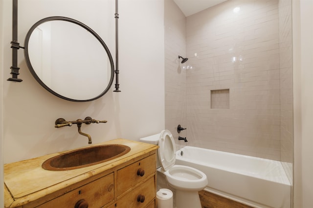 full bathroom with hardwood / wood-style floors, large vanity, toilet, and tiled shower / bath combo