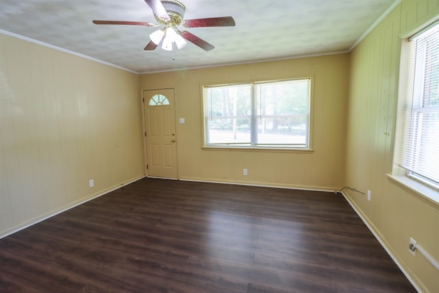 spare room featuring crown molding, a wealth of natural light, dark hardwood / wood-style floors, and ceiling fan