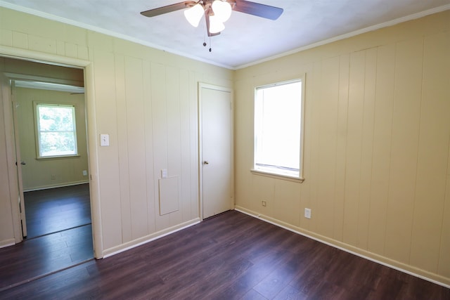 unfurnished bedroom with ornamental molding, dark hardwood / wood-style floors, a closet, and ceiling fan