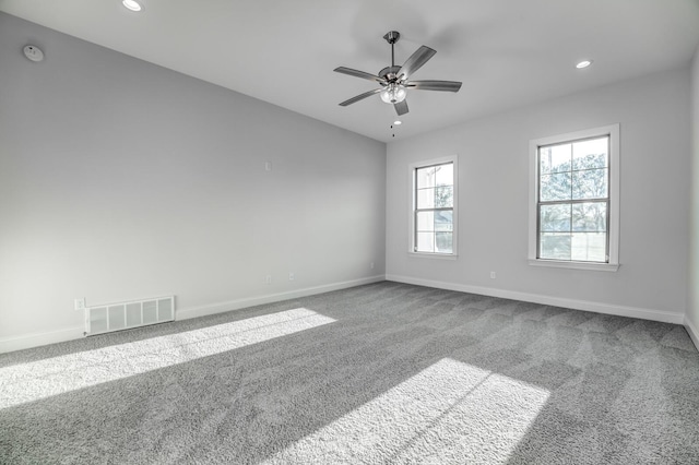 carpeted empty room featuring baseboards, visible vents, and recessed lighting