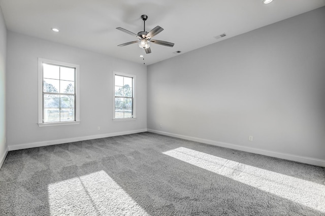 spare room with carpet floors, visible vents, and baseboards