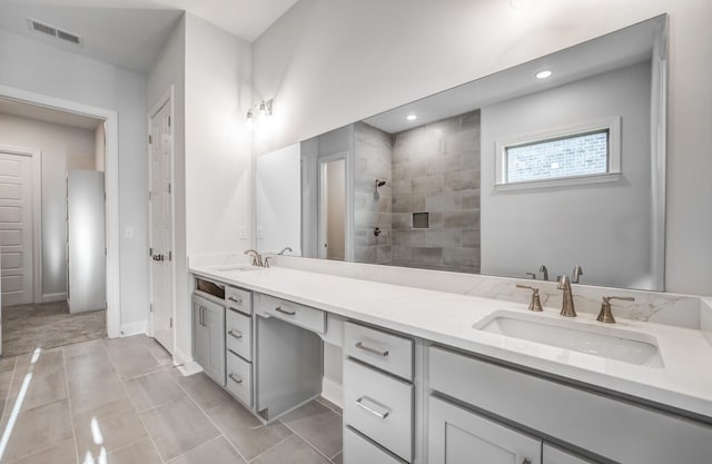 bathroom featuring tiled shower, tile patterned floors, and vanity