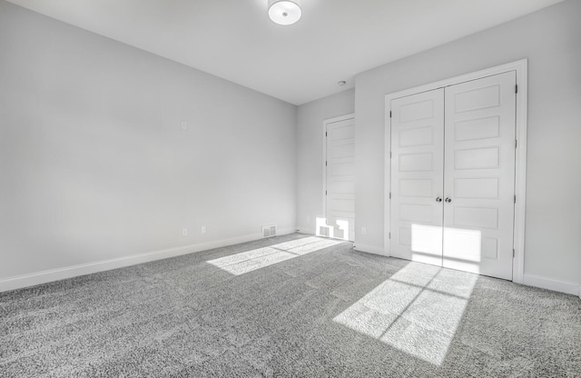 unfurnished bedroom featuring a closet and light colored carpet