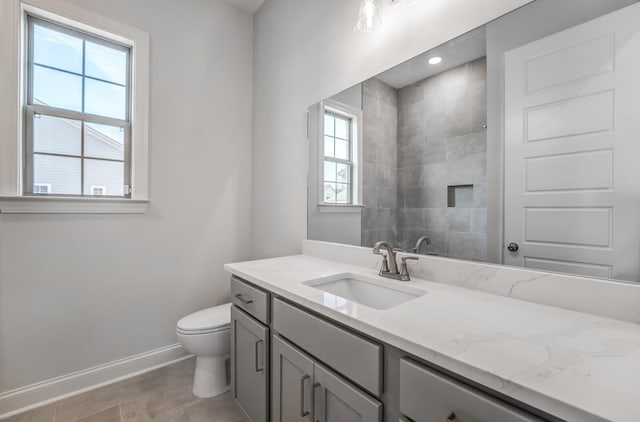 full bathroom with baseboards, toilet, tile patterned floors, a tile shower, and vanity