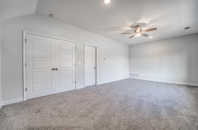 unfurnished bedroom featuring ceiling fan, vaulted ceiling, and carpet floors