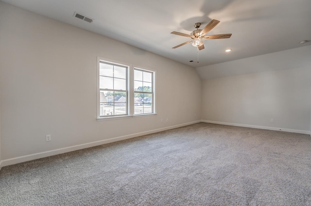 carpeted empty room featuring lofted ceiling, recessed lighting, visible vents, ceiling fan, and baseboards