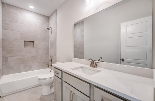 full bathroom featuring toilet, tiled shower / bath, vanity, and tile patterned floors