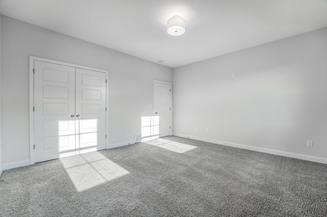 unfurnished bedroom with a closet and light colored carpet