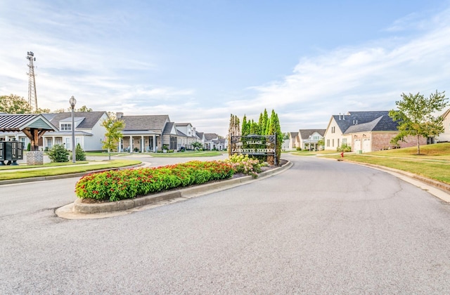 view of street featuring a residential view, curbs, sidewalks, and street lights